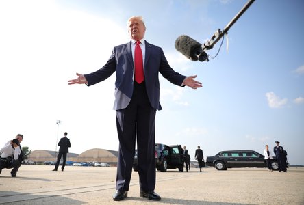 U.S. President Donald Trump talks to reporters as he boards Air Force One for travel to Mount Rushmore from Washington