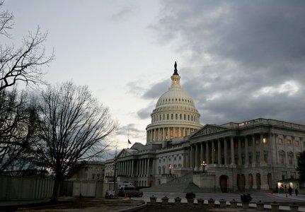 The dome of the United States Capitol building is illuminated at twilight as the [U.S. Congress and ..