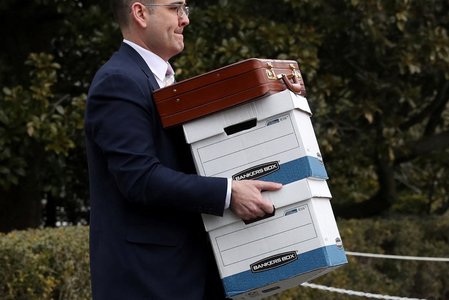 White House aides carry file boxes during travel with President Trump