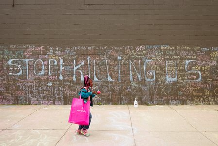 Child walks past a memorial at the scene of a weekend shooting at a Tops supermarket in Buffalo, New York