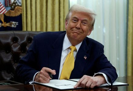FILE PHOTO: FILE PHOTO: U.S. President Donald Trump signs an executive order in the Oval Office of the White House in Washington