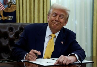 FILE PHOTO: FILE PHOTO: U.S. President Donald Trump signs an executive order in the Oval Office of the White House in Washington