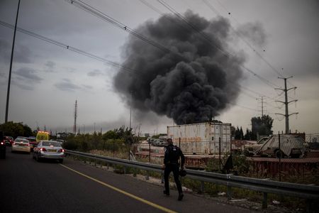 A policeman runs to an impact site following an Iranian missile strike, amid the U.S.-Israeli conflict with Iran, in central Israel
