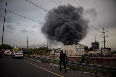A policeman runs to an impact site following an Iranian missile strike, amid the U.S.-Israeli conflict with Iran, in central Israel